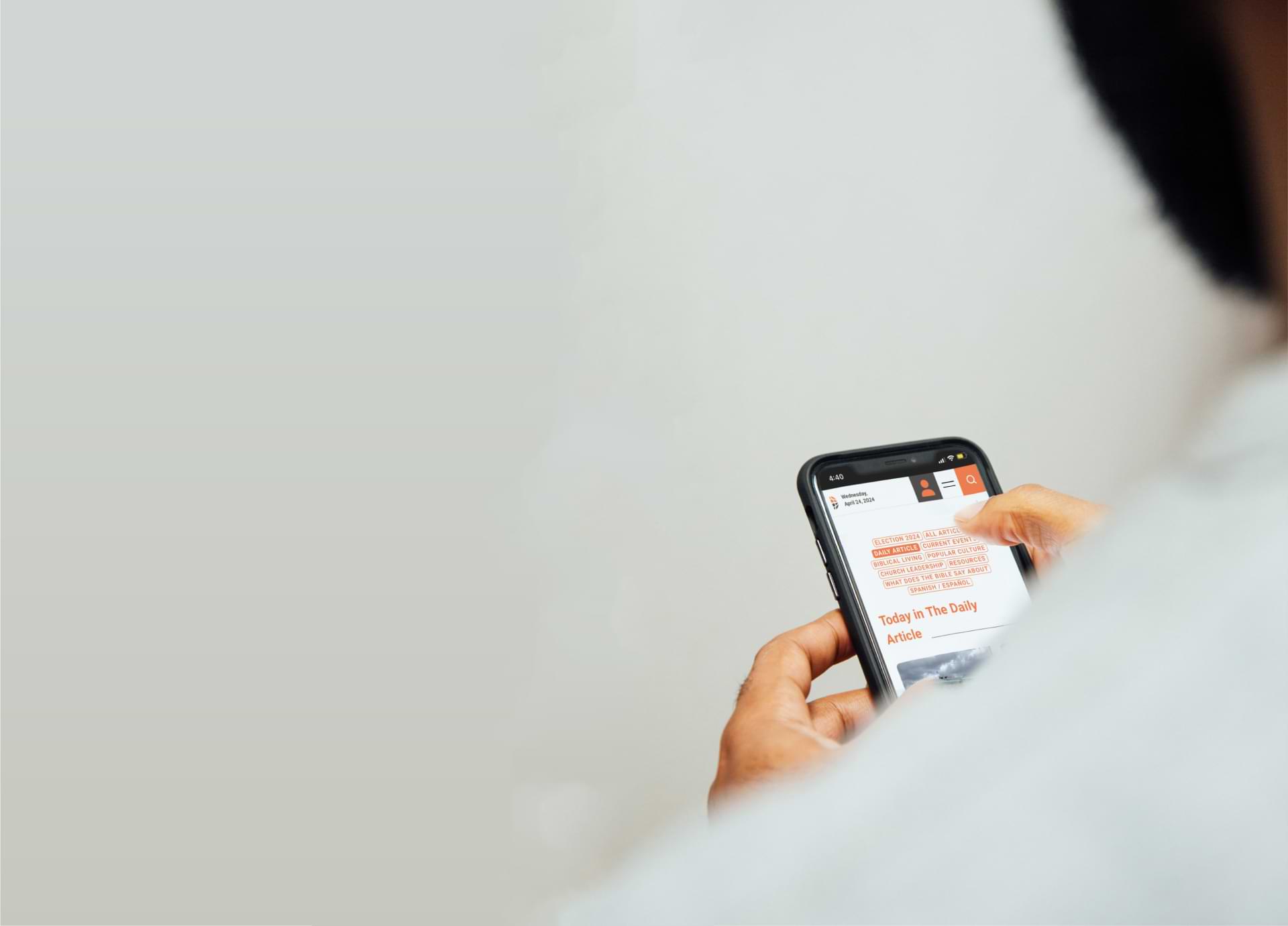 Image of a guy looking at denisonforum.org on his phone